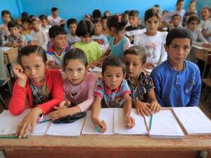 أطفال يحضرون حصتهم الأولى بعد تسجيلهم مباشرة في مدرسة في حزيمة بشمال الرقة بسوريا
