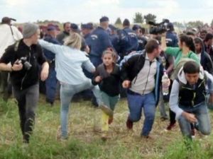 ظهرت بيترا لازلو (الثانية من اليسار) في شريط صوره صحافيون اخرون، وهي تحمل كاميرا وتوجه ركلات الى رجل وابنه اوقعتهما ارضا
