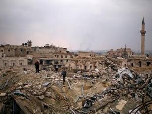 احد مقاتلي قوات الجيش السوري ومدني يقفان على حطام فندق كارلتون في منطقة خاضعة تحت سيطرة الحكومة في حلب 
