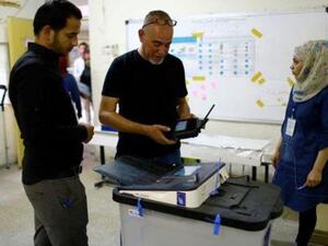 موظف بمفوضية الانتخابات العراقية يغلق صندوق اقتراح بمركز اقتراع في مدينة الصدر

