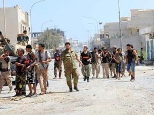 مقاتلون من القوات الليبية المتحالفة مع الحكومة المدعومة من الأمم المتحدة بتخذون مواقعهم أثناء معركة مع مقاتلي الدولة الإسلامية في سرت في ليبيا
