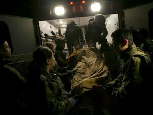 جنود إسرائيليون يدخلون مصابا سوريا عربة إسعاف تابعة للجيش الإسرائيلي على الحدوج بين إسرائيل وسوريا عند مرتفعات الجولان
