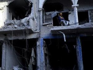 يجلس على شرفة مبنى مدمر في الرقة السورية التي استعادها مقاتلون غالبيتهم من الاكراد من ايدي تنظيم الدولة الاسلامية الخريف الماضي
