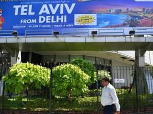 رجل هندي يمر امام اعلان عن الرحلات الجديدة المباشرة بين نيودلهي وتل ابيب في بومباي 
