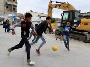 أطفال يلعبون بالكرة في حي التضامن الشعبي في ضاحية تونس
