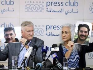 والدا الصحافي المخطوف في سوريا يرفعان صورا لابنهما خلال مؤتمر صحافي في بيروت
