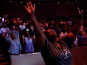 أناس يقفون أثناء قداس لأفراد الشرطة في كنيسة في دالاس بولاية تكساس
