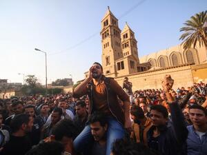 Egyptians shout slogans as they gather outside the the Saint Peter and Saint Paul Coptic Orthodox Church in Cairo's Abbasiya neighborhood after it was targeted by a bomb explosion on December 11, 2016. (AFP/Mohamed Muteab)