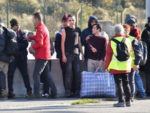 Young migrants wait to board a bus leaving for a reception center, in Calais, on October 28, 2016, following a massive operation to clear the "Jungle" migrant camp. (AFP/Philippe Huguen)