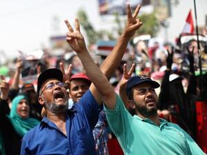 Egyptian supporters of deposed president Mohamed Morsi flash the sign for victory as they shout slogans during a rally in support of the former Islamist leader (Mahmud Hams / AFP)