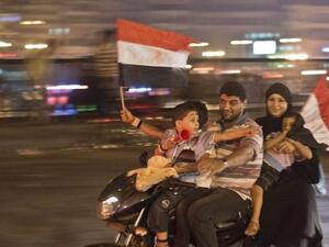 An Egyptian family on motorcycle celebrates in Cairo on July 3 after a broadcast by the head of Egypt's army suspended the constitution (Khaled Desouki / AFP)