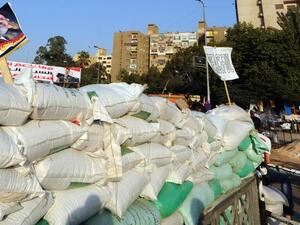 EGYPT, Cairo : A supporter of Egypt's deposed president Mohamed Morsi (portrait-L) walks past a barricade in Cairo on July 31, 2013. AFP PHOTO / FAYEZ NURELDINE