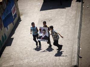 Egyptian children run while holding a portrait of ousted president Mohamed Morsi during a demonstration in support of Morsi in Cairo, on August 9, 2013. AFP PHOTO/GIANLUIGI GUERCIA
