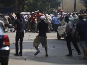 EGYPT, Cairo : Local residents (front) throw stones towards supporters of ousted president Mohamed Morsi during clashes in downtown Cairo on August 13, 2013.  AFP PHOTO/GIANLUIGI GUERCIA