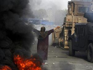 EGYPT, Cairo : An Egyptian woman tries to stop a military bulldozer from going forward during clashes that broke out as Egyptian security forces moved in to disperse supporters of Egypt's deposed president Mohamed Morsi in a huge protest camp near Rabaa al-Adawiya mosque in eastern Cairo on August 14, 2013. AFP PHOTO /MOHAMMED ABDEL MONEIM