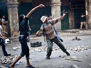 EGYPT, Cairo : Supporters of ousted president Mohamed Morsi throw stones as they clash with security officers in Cairo's Ramses Square, on August 16, 2013. AFP PHOTO / VIRGNIE NGUYEN HOANG