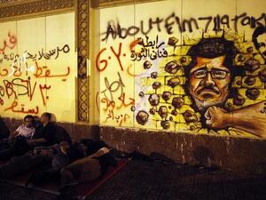 Egyptian opposition demonstrators calling for the ouster of President Mohamed Morsi sleep next to a wall covered in anti-Morsi graffiti (Mahmud Khaled / AFP)