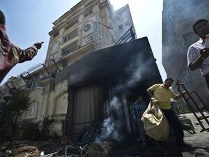 Egyptian men carry items looted from the burnt headquarters of the Muslim Brotherhood (Khaled Desouki / AFP)