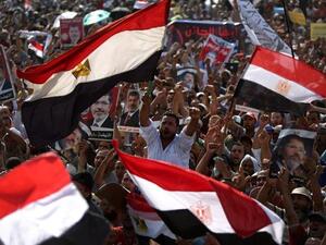 Supporters of Egypt's ousted President Mohamed Morsi wave their national flag as they attend a rally in support of the former Islamist leader outside Cairo's Rabaa al-Adawiya mosque (AFP)