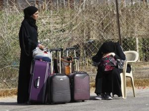 Palestinians wait near their luggage at the Rafah border terminal in the southern Gaza Strip before crossing into neighbouring Egypt on August 24, 2013. AFP PHOTO SAID KHATIB