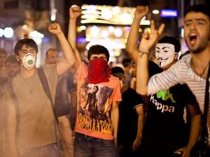 Protestors chant slogans behind a barricade on July 14, 2013 in the center of Istanbul.  AFP PHOTO /GURCAN OZTURK