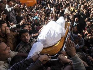 Egyptians carry the body of one of the thirteen people killed in a car bomb attack earlier in the day, during his funeral in the Egyptian city of Mansura, North of Cairo. [AFP]