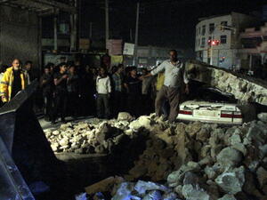 Iranians gathering amid rubble in the Iranian western city of Borazjan, on November 28, 2013, after a 5.7 magnitude earthquake struck the country. [Mohammad Salehinia/AFP]