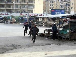 People run for cover from sniper fire in the Lebanese northern coastal city of Tripoli on December 1, 2013. [AFP]