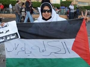 متظاهرة مصرية في القاهرة ترفع العلم الفلسطيني/أ.ف.ب