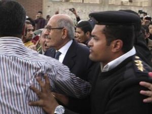 المدير العام السابق للوكالة الدولية للطاقة الذرية محمد البرادعي (في المنتصف) يغادر مركز اقتراع في القاهرة