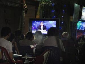 A file picture shows Egyptians watching comedian Bassem Youssef's show as they sit at a public coffee shop.  (Image credit: AFP)