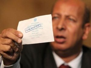 احد اعضاء حزب الوفد يحمل صوتا يقول حزبه انه مزور خلال مؤتمر صحافي في مقر الحزب في القاهرة الخميس