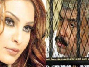 طلعت مصطفى وراء القضبان والى يساره صورة للمغنية القتيلة