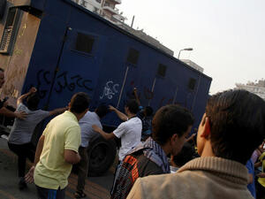 Supporters of Egyptian ousted president Mohamed Morsi attack a police vehicle in Cairo's eastern Nasr City district on October 11, 2013, after clashes broke out during a demonstration against the military. (Image credit: AFP)