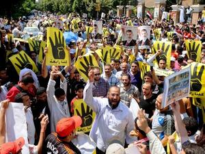 EGYPT, Cairo : Supporters of the Muslim Brotherhood and Egypt's toppled president Mohamed Morsi (portrait) take part in a demonstration in Hilwan, south of Cairo, on August 30, 2013.AFP PHOTO/STR