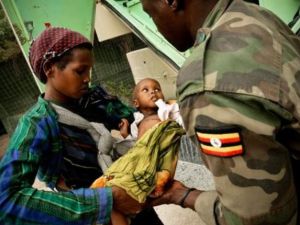 طبيب من مهمة الاتحاد الافريقي في الصومال يعاين طفلا يعاني من سوء التغذية في مقديشو
