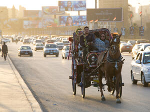 A family rides in a horse-drawn carriage on a busy road in Cairo, Egypt. (Shutterstock)