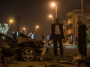 Egyptian officials inspect the wreckage of a car bomb that exploded in a Cairo suburb after Egypt's deputy prosecutor general drove by late on September 29, 2016, wounding a passerby. (AFP/Khaled Desouki)