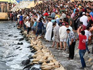 Egyptians stand on the shore as they wait for the recovery of bodies, during a search operation after a boat carrying migrants capsized in the Mediterranean, along the shore in the Egyptian port city of Rosetta on September 22, 2016. (AFP/Mohamed El-Shahed)