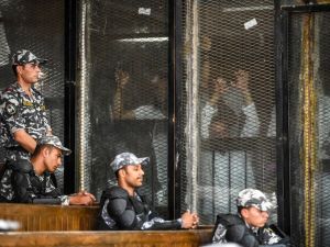Members of Egypt's banned Muslim Brotherhood are seen inside a glass dock during their trial in the capital Cairo on July 28, 2018. (AFP/Khaled Desouki)