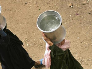 Egyptian women walk with containers filled with water in al-Rahawe Village, outside Cairo, May 27, 2010. (AFP)