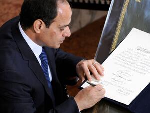 A handout picture made available on June 8, 2014 by the Egyptian presidency shows former army chief Abdel Fattah al-Sisi signing the handing over of power document from outgoing interim president Adly Mansour in Cairo. (AFP/Egyptian Presidency) 