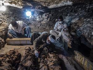A picture taken on September 9, 2017 shows Egyptian labourers and archaeologists unearthing mummies at a newly-uncovered ancient tomb for a goldsmith. (Khaled Desouki/AFP)