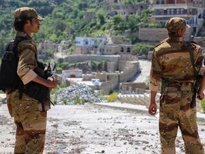 Fighters survey the ongoing damage in the Taez province. (AFP/Ahmad al-Basha)