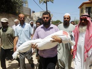 ارشيف/ فلسطيني يحمل جثمان شهيد سقط خلال عدوان اسرائيل الاخير على غزة