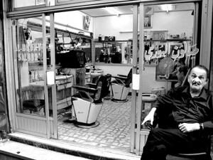 A man sits outside of his barber shop in Amman, Jordan.  Many older residents of the city's historic neighborhoods feel that the up-and-coming hipster scene is pushing them away.  (Albawaba/Madeline Edwards)