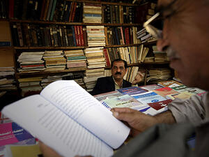 A customer browses books in a shop on Mutanabi Street, famed as Baghdad's bookselling district.  A scarcity of science literature available in Iraq inspired the Real Sciences group to translate works into Arabic.  (AFP/Joseph Eid)