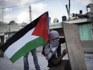 A Palestinian man takes cover at Qalandiya checkpoint between Ramallah and Jerusalem on September 23, 2011.  (AFP/Alessio Romenzi)