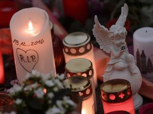 A candle reading 'RIP' and the date of the Christmas market's attack stands next to an angel figure near the terror attack site in Berlin on December 21, 2016. (AFP/Clemens Bilan)