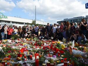 People mourn at a memorial on July 24, 2016 in front of the Olympia Einkaufszentrum shopping center in Munich, Germany, where an 18-year-old German-Iranian student shot and killed nine people. (AFP/Christof Stache) People mourn at a memorial on July 24, 2016 in front of the Olympia Einkaufszentrum shopping center in Munich, Germany, where an 18-year-old German-Iranian student shot and killed nine people. (AFP/Christof Stache)